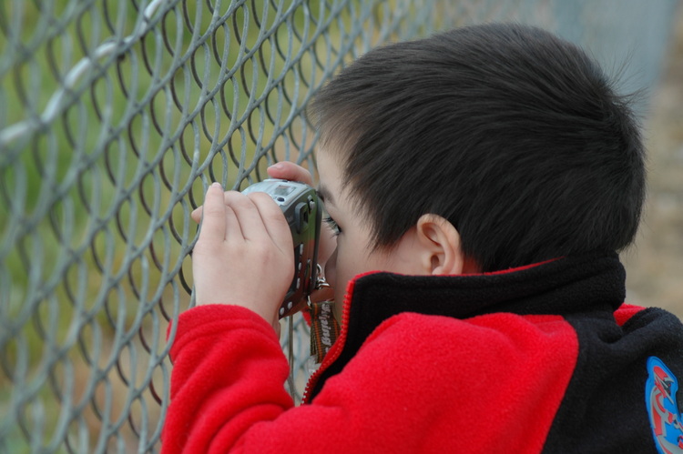 Michael composes a shot through the fence