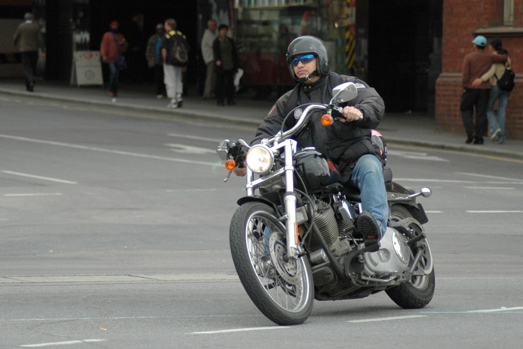 A guy on a motorcycle, in the city