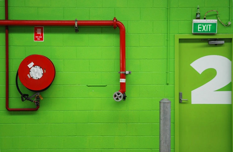 Red fire equipment against lime green bricks