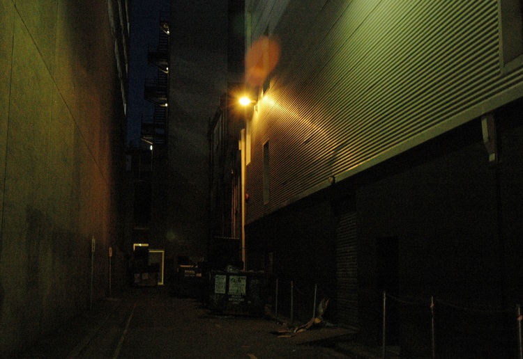 A dark street, lit by a single light