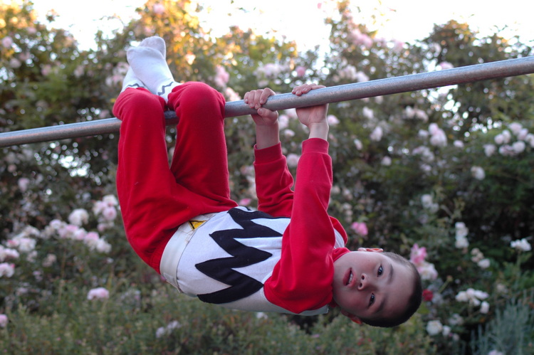 Michael hangs from a monkey bar