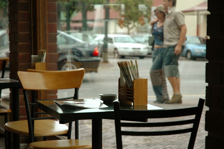 A view into the street, past an empty table