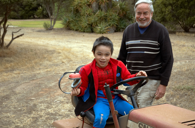 Michael sits proudly on a ride-on mower