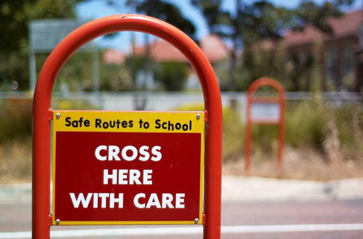 Sign reading 'safe routes to school', 'cross here with care'