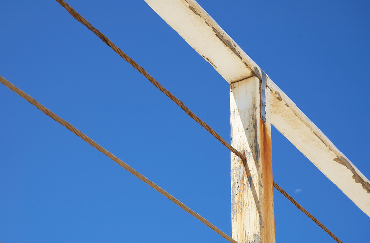 A white handrail against a blue sky