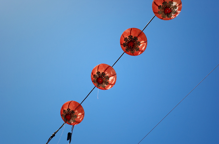 Red paper lanterns against a blue sky