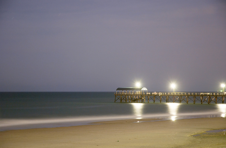 Jetty, beach, and sky at night