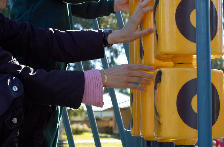 Hands reaching out to a big noughts and crosses board