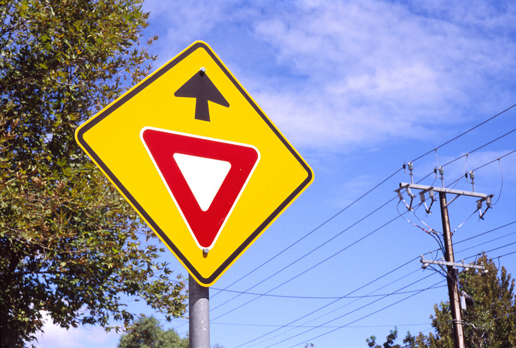 A warning road sign against a blue sky