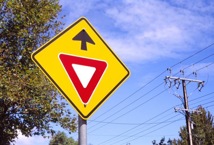 A warning road sign against a blue sky