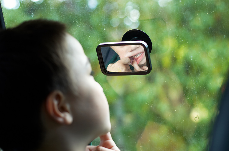 Michael checks his teeth in a convex mirror