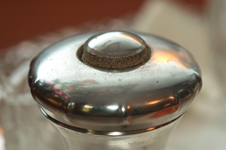 Closeup of the top of a silver pepper mill