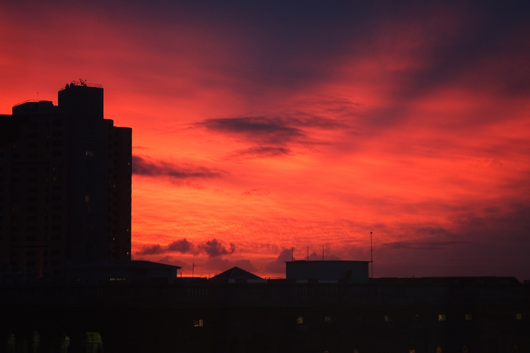 Deep red sunset over city skyline