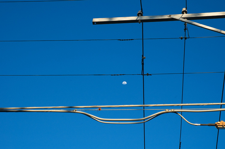 Utility wires, against a blue sky and the moon