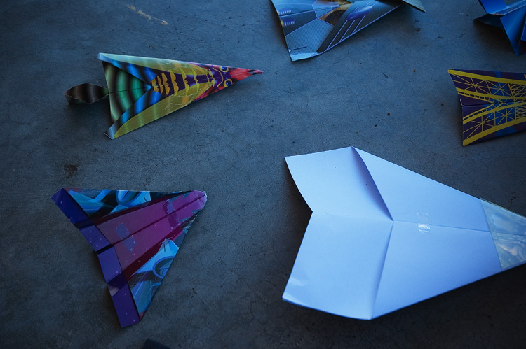 An array of paper planes, lying on the ground