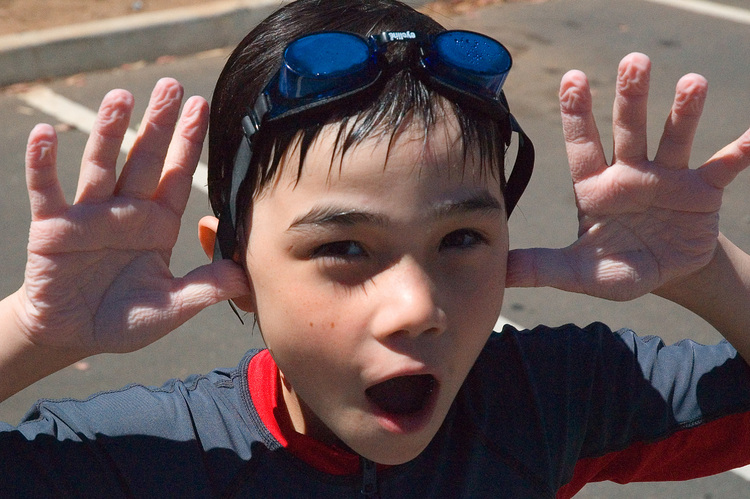 Michael holds up his hands to show them wrinkled from being in the pool