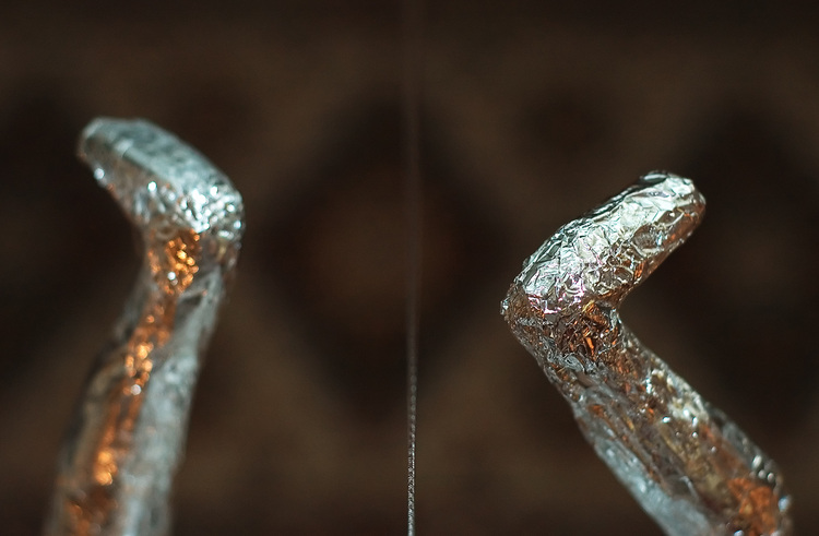 The silver feet of a Spider-Man doll, hanging upside down