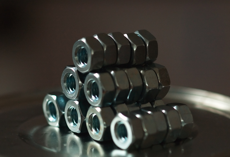 An arrangement of nuts (nut and bolt nuts) on the top of a tin