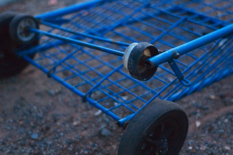 A blue cart, abandoned by the side of the road