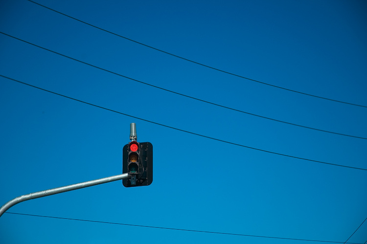 An overhead traffic light, surrounded by power lines