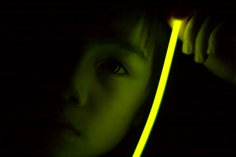 Michael holding a glow-stick next to his face