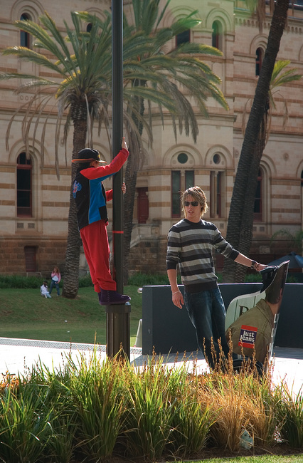 Michael hanging from a pole, chating to a guy on a Segway