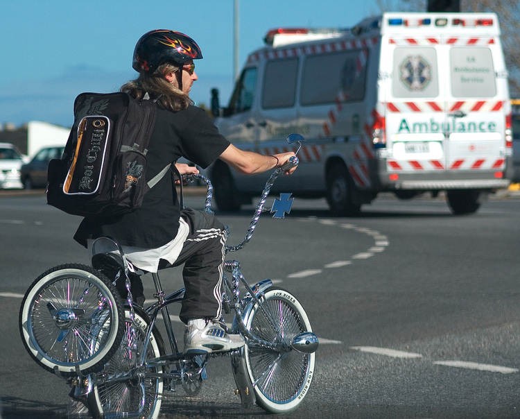 A man on a bicycle finished in chrome, and with white-walled tyres