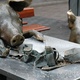 Bronze pig rummages though a rubbish bin