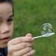 Michael holds a bubble on a bubble blower