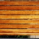 Wooden slats cover a gap in a concrete fence