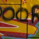 The word 'poor' sprayed over other graffiti