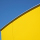 A large yellow wall against a bright blue sky