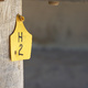 A yellow tag on a wooden pylon