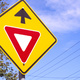 A warning road sign against a blue sky