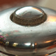 Closeup of the top of a silver pepper mill