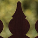 Three fence pickets silhouetted against foliage