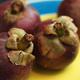 Several Mangosteen fruit, on a plate