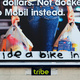 'ride a bike instead' graffitied across a billboard