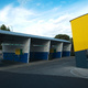 A bright yellow car-wash, against a blue sky