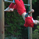 Michael swinging, upside down, on a bar