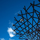 Looking up at a fountain/sculpture with a deep blue sky beyond