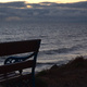 An empty bench, looking out over the sea at dusk