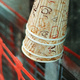 Paper coffee cups hanging from the top of a piece of metal on a construction site